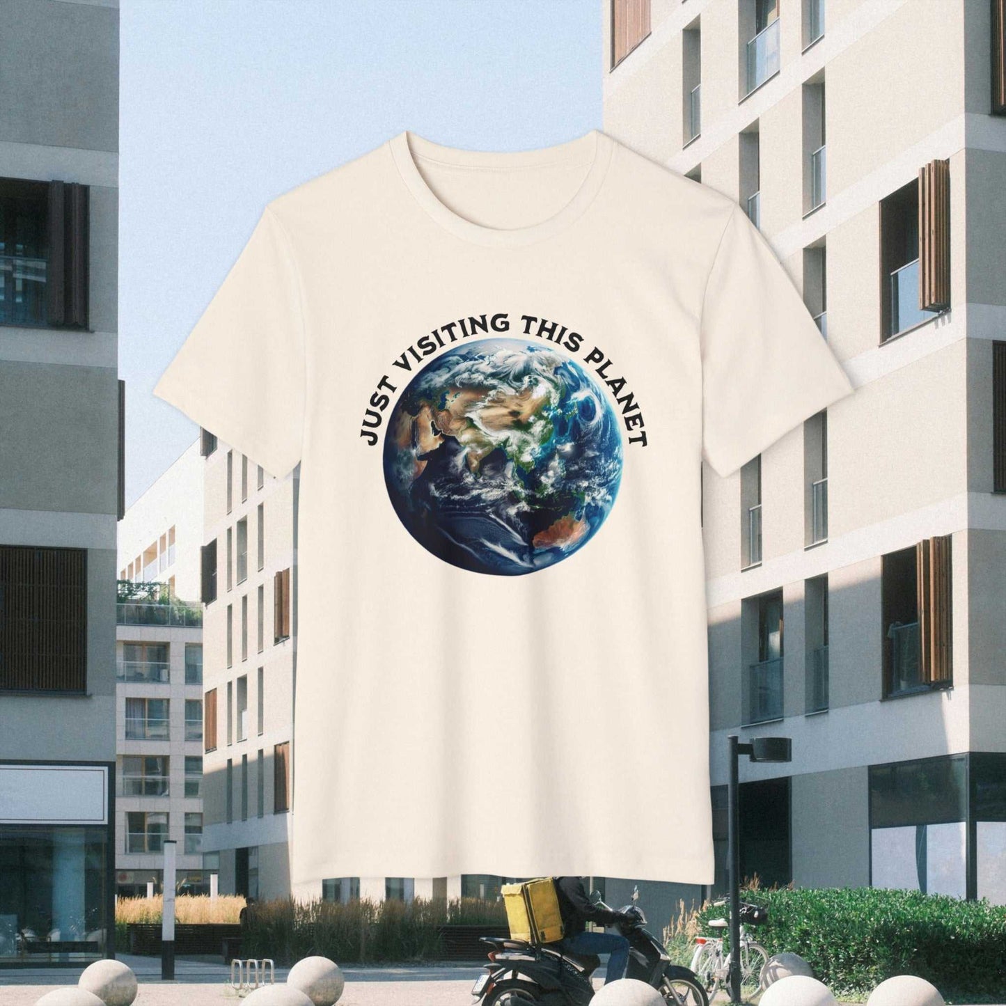 Just Visiting This Planet text w Earth graphic on a natural Tee