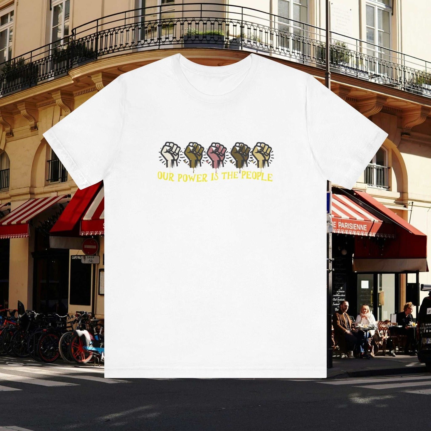 Empowering text 'Our Power is the People' with diversity raised fist on a white tee, city background