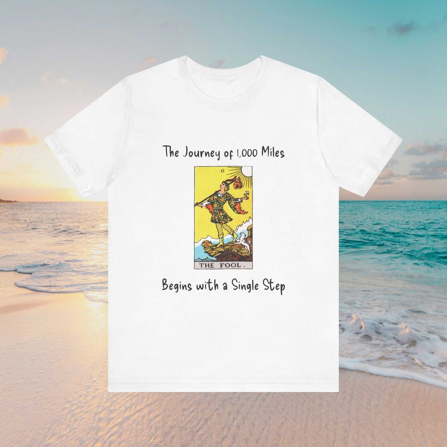 The Fool tarot graphic and text of 'The Journey of 1,000 Miles Begins with a Single Step" on a white tee