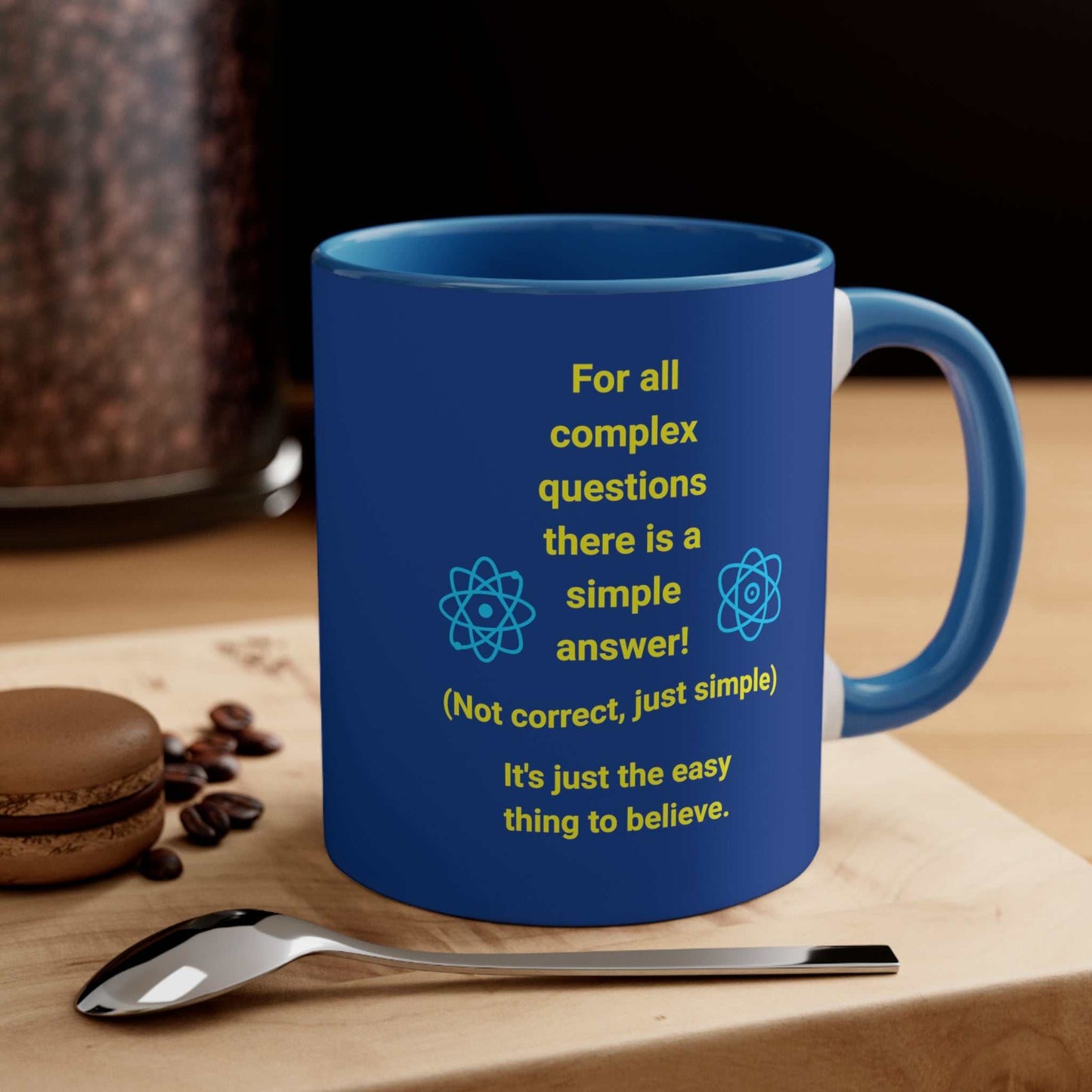 Navy blue mug with blue handle and inside, with quote "Complex Questions" on a woodblock with spoon and cookie