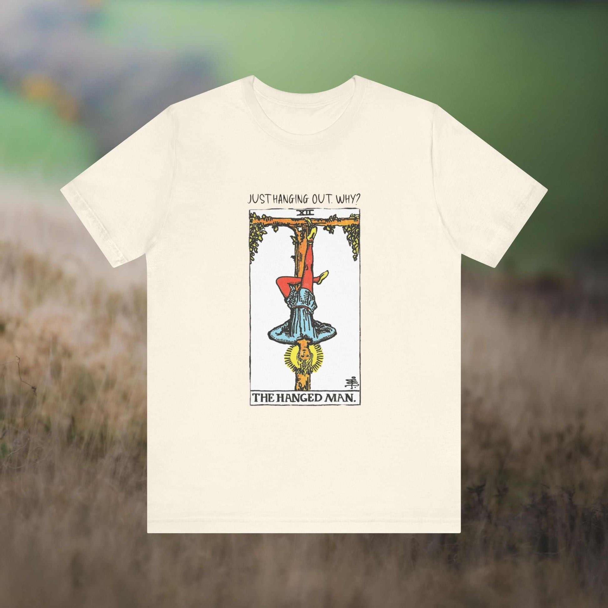 Hanged Man Tarot w text "Just Hanging Out, Why?' on a natural tee