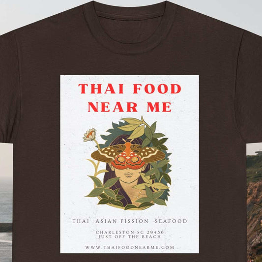 Thai Food Near Me text with graphic of young woman's head with butterfly eyes surrounded by leaves, with white background on a dark chocolate tee