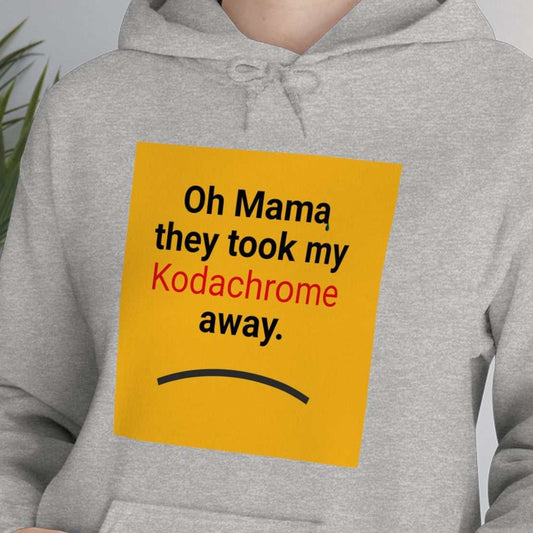 Kodachrome yellow square with text "Oh Mama they took my Kodachrome away!" sad line, on young woman with athletic hoodie.