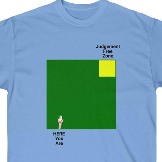 Judgement Free Zone text above a yellow square within large green block, opposite from HERE You Are hand graphic, on a Light blue tee 