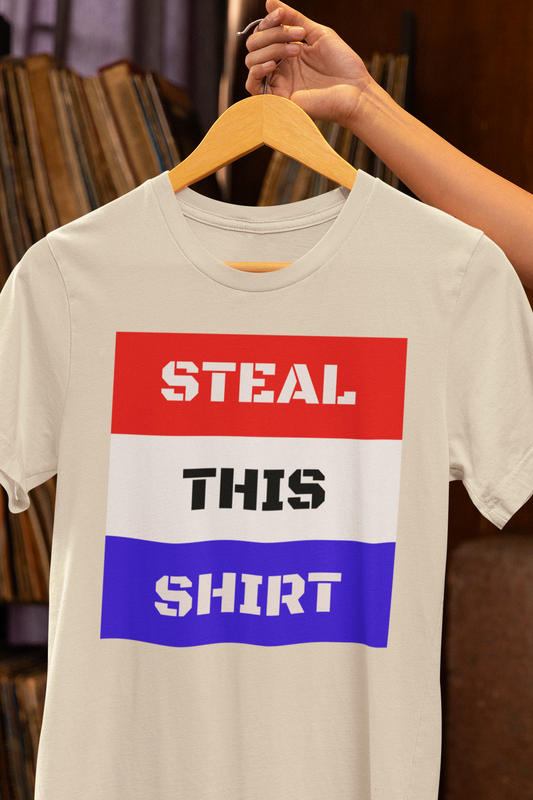 STEAL THIS SHIRT text with red white and blue background on a heather natural colored tee